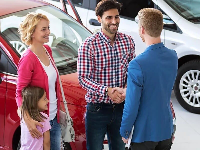 Businessman shaking hands with smiling customer family